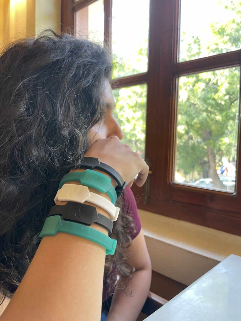 woman wearing 5 Tapr bands on her wrist, in multiple colours. 